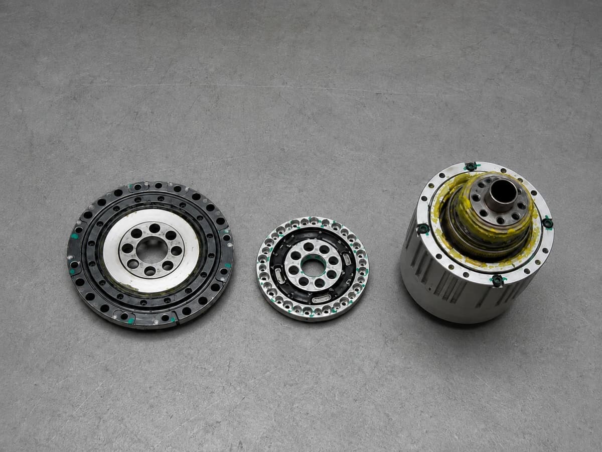Disassembled OS3 actuator components on a gray workbench