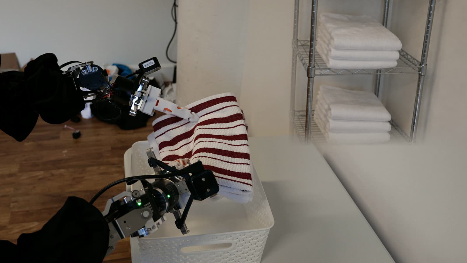 The arms of HALE 1.0 beside folded linens on a table
